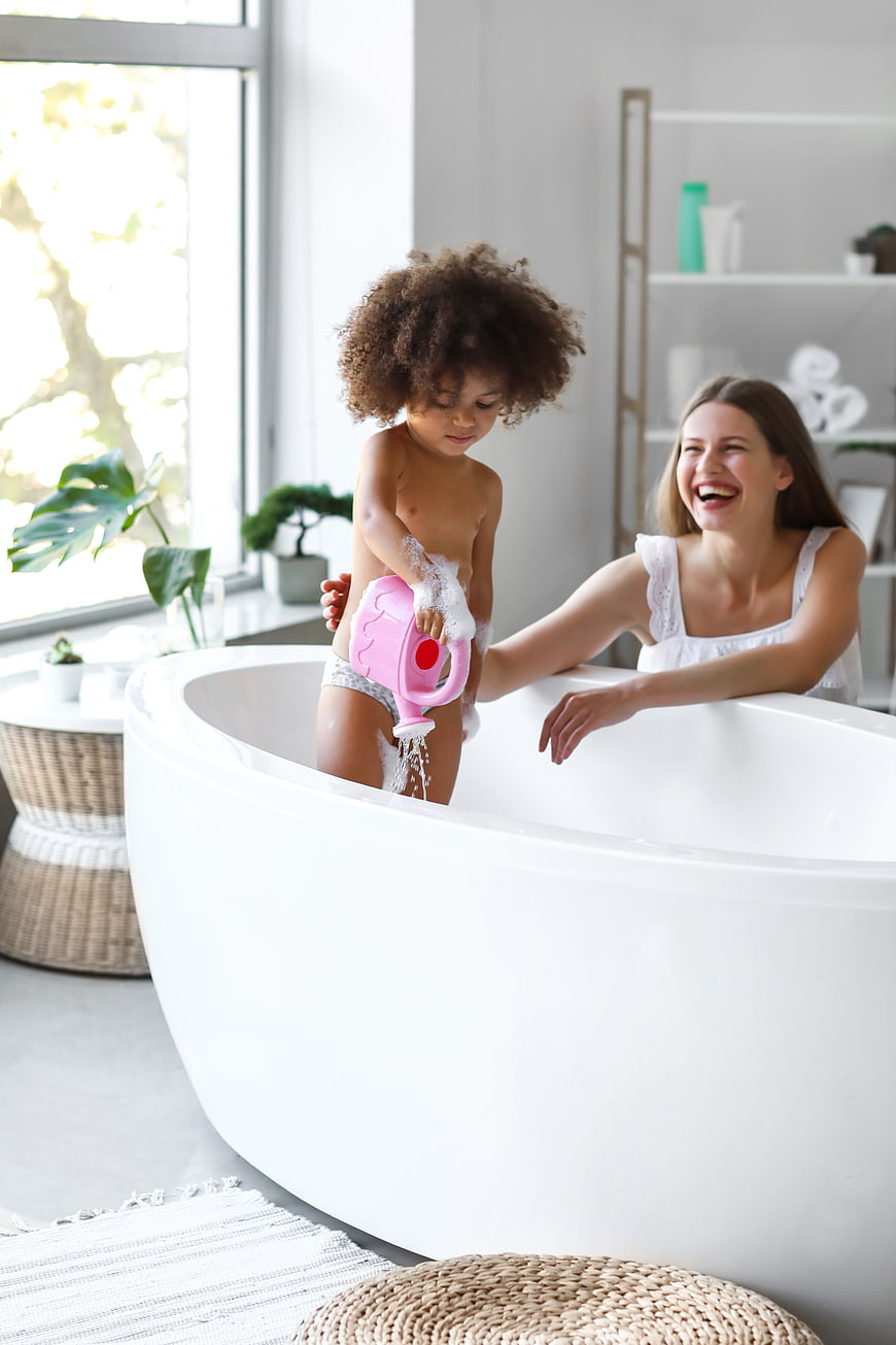Happy Mother and Toddler Playing in Bathtub
