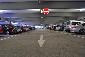 One Way Arrow in Indoor Parking Garage with Parked Cars
