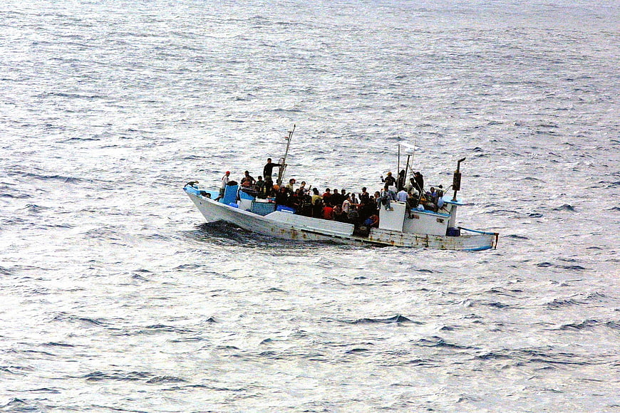 Overcrowded refugee boat on open sea