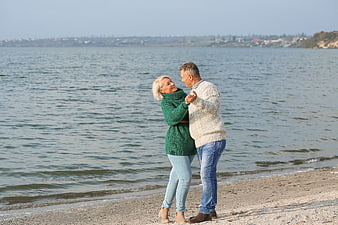 Happy Senior Couple Dancing on Sandy Beach