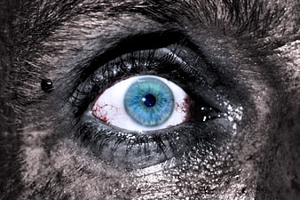 Extreme Close-Up of a Blue Eye with Red Veins on Decayed Skin