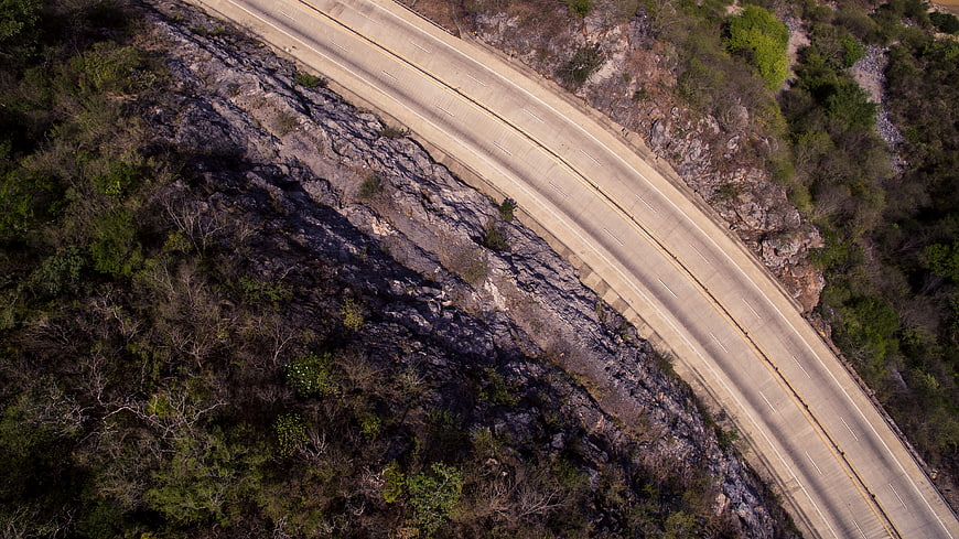 Aerial view of winding highway through rocky canyon landscape