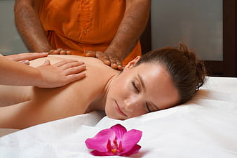 Woman Receiving Four-Hand Spa Massage With Orchid