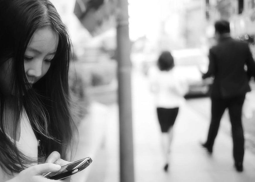Woman Using Smartphone on Busy City Street