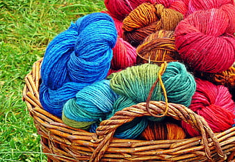 Colorful Hand-Spun Wool Skeins in Wicker Basket on Grass