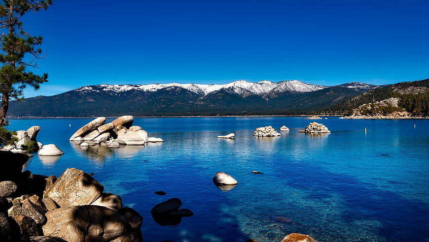 Crystal Clear Blue Lake Tahoe Water with Snowy Mountains