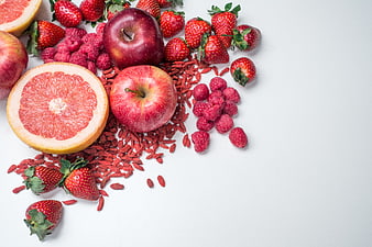 Top view of red fruits and berries on white background