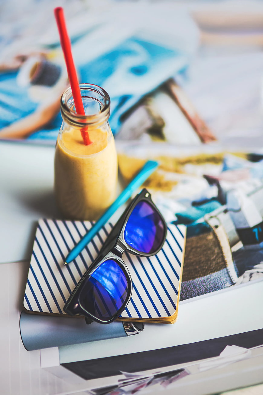 Summer travel accessories with sunglasses and smoothie