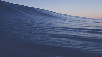 Serene Blue Ocean Wave at Dusk with Soft Horizon