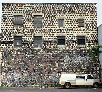 White Van Parked Against Textured Stone Building Facade