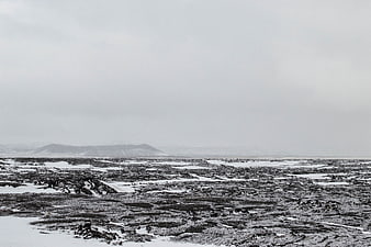 Desolate black and white winter landscape with snow-covered volcanic terrain