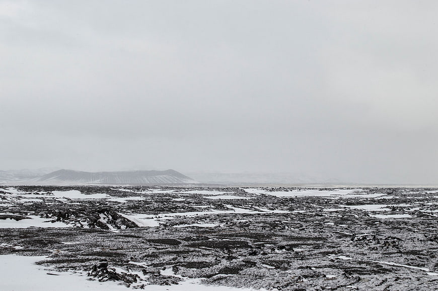Desolate black and white winter landscape with snow-covered volcanic terrain