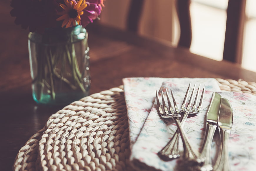 Rustic Dining Table Setting with Silverware and Flowers