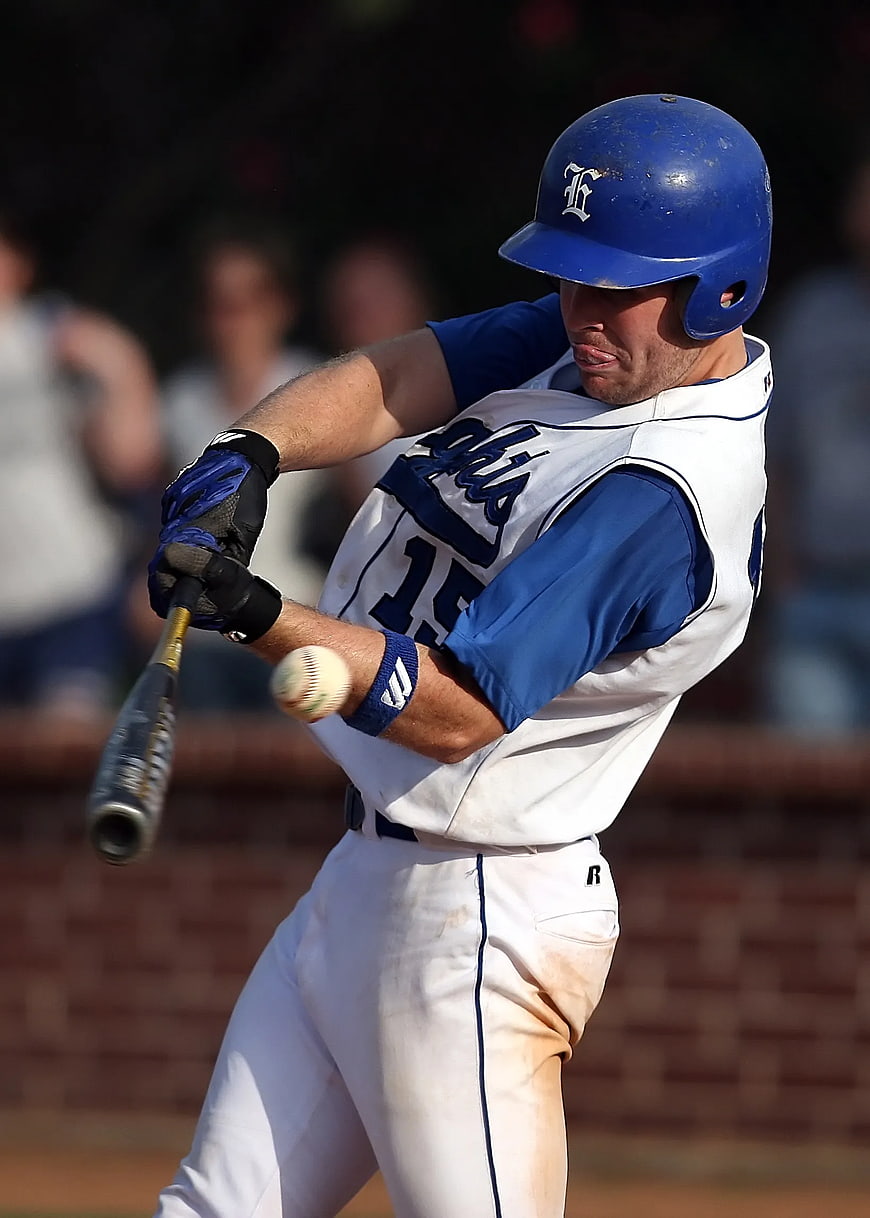 Baseball Player Swinging Bat in Blue and White Uniform