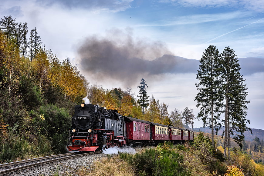 Vintage steam locomotive train on autumn mountain railway