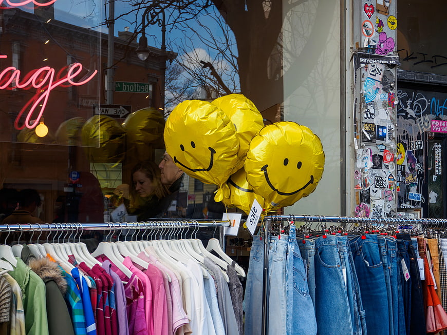 Vintage Clothing Storefront with Yellow Smiley Balloons