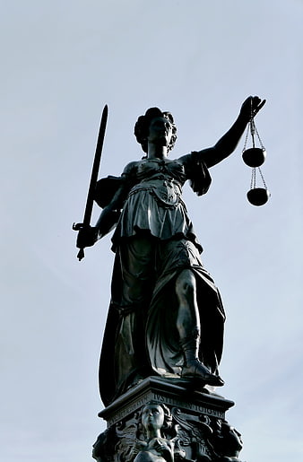 Justitia Statue Holding Sword and Scales Against Sky