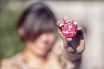 Woman holding red I'm a winner button close up