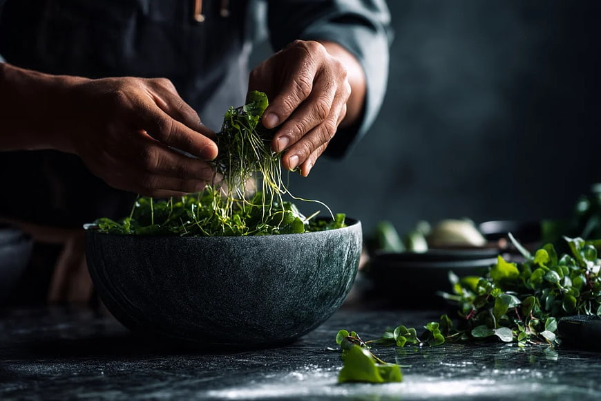 Chef Hands Plating Fresh Microgreens in Stone Bowl