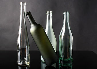 Assorted Empty Glass Bottles on Dark Background