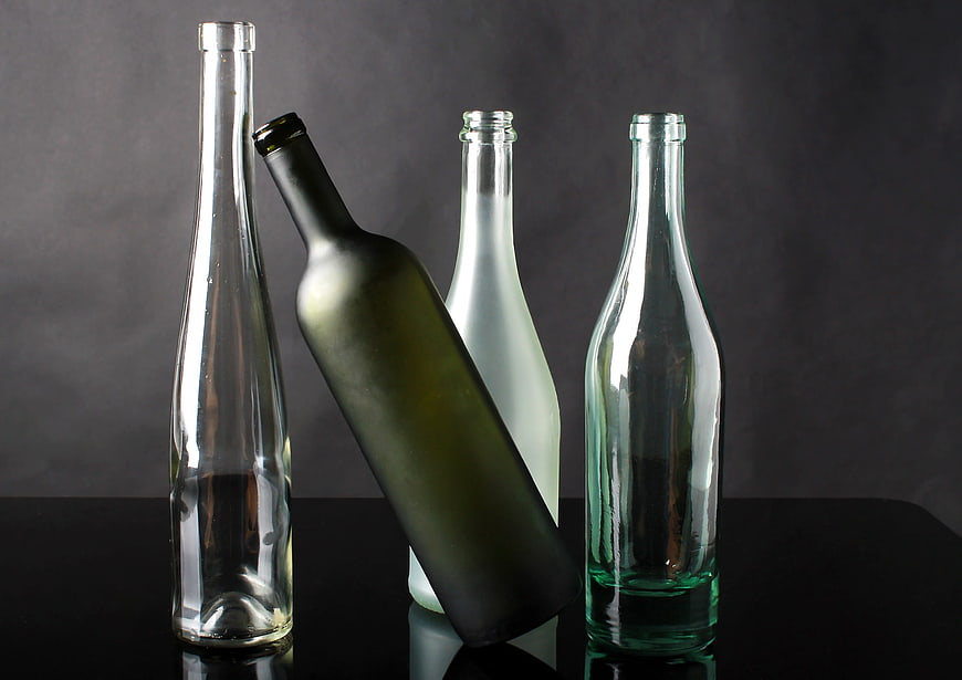 Assorted Empty Glass Bottles on Dark Background