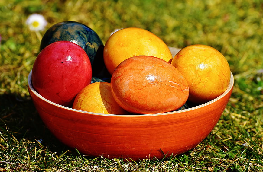 Colorful Easter Eggs in Wooden Bowl on Grass