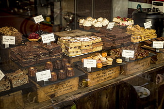 Artisan bakery display with brownies, macarons, and cakes in wooden crates