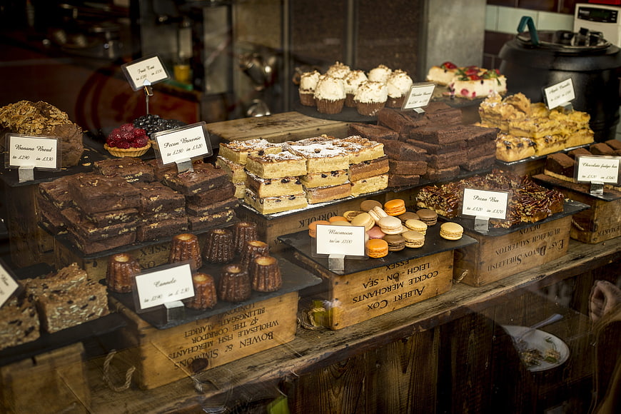 Artisan bakery display with brownies, macarons, and cakes in wooden crates