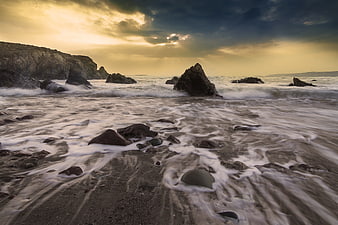 Dramatic Long Exposure Rocky Beach at Sunset with Golden Sky