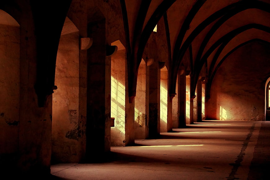 Sunlit Gothic Arches in Ancient Stone Hallway