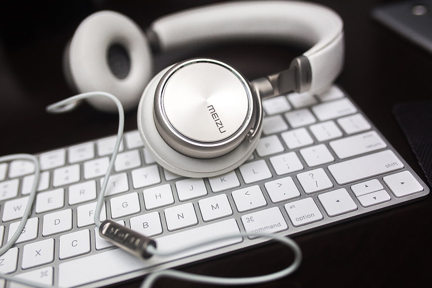 White Meizu Headphones on Silver Keyboard