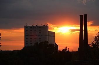 Industrial Silhouette Against Vibrant Orange Sunset Sky