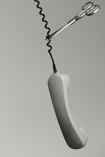 Scissors cutting telephone cord concept