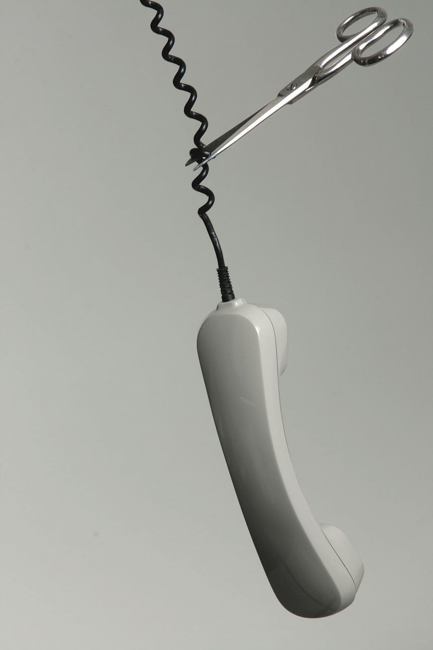 Scissors cutting telephone cord concept