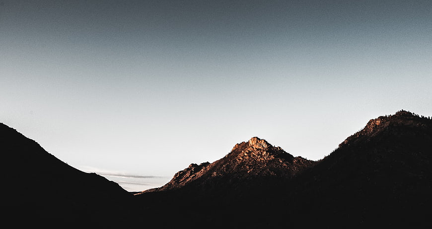 Silhouette of Mountain Peaks Against Gradient Sky