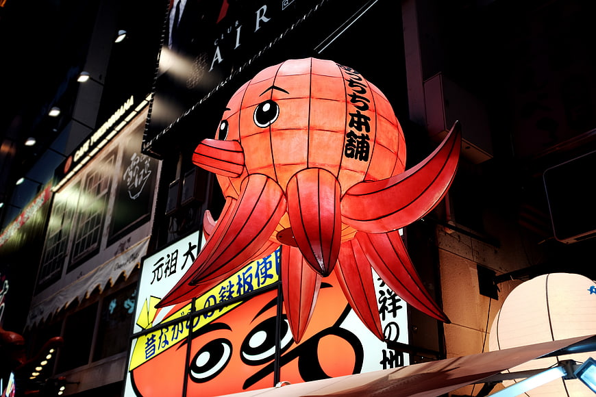 Giant red octopus lantern hanging in Japanese street at night