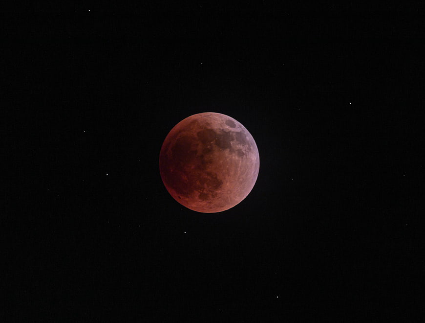 Red Lunar Eclipse Against Black Night Sky