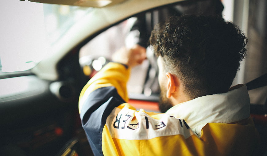 Man in Yellow Jacket Driving Car Interior
