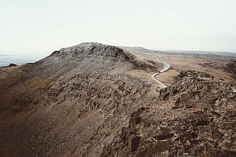 Aerial View of Winding Road Through Rocky Mountainous Desert Landscape