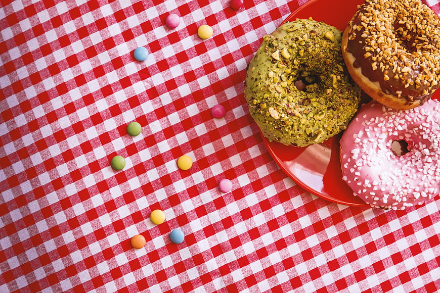 Colorful Donuts on Red Plate with Gingham Tablecloth