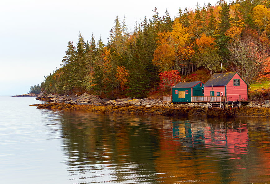 Colorful Boathouses on Rocky Autumn Coastline with Reflections