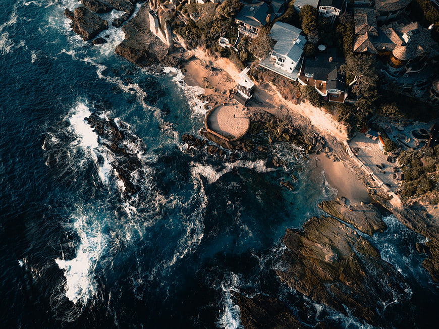 Aerial View of Coastal Houses and Rocky Shoreline
