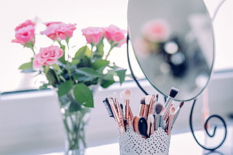 Pink Roses and Makeup Brushes on Vanity Table