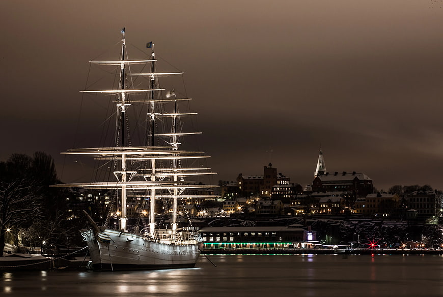 Illuminated Tall Ship in Winter Harbor at Night