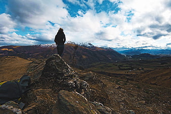 Woman Hiking on Rocky Mountain Peak with Snowy Vista