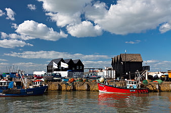 Fishing boats docked at English Harbour with black buildings
