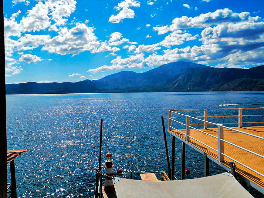 Sunny Lake View with Wooden Dock and Mountains
