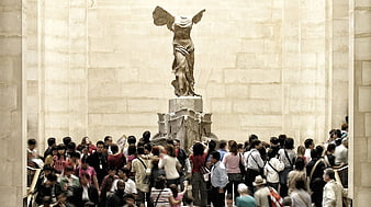 Crowd of tourists viewing the Winged Victory of Samothrace at the Louvre