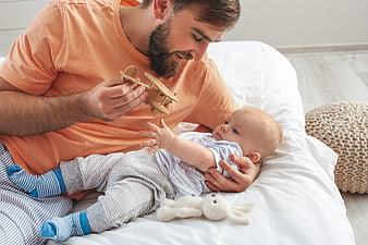 Father Playing with Baby and Wooden Toy Airplane