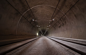 Perspective view of empty concrete tunnel with railway tracks